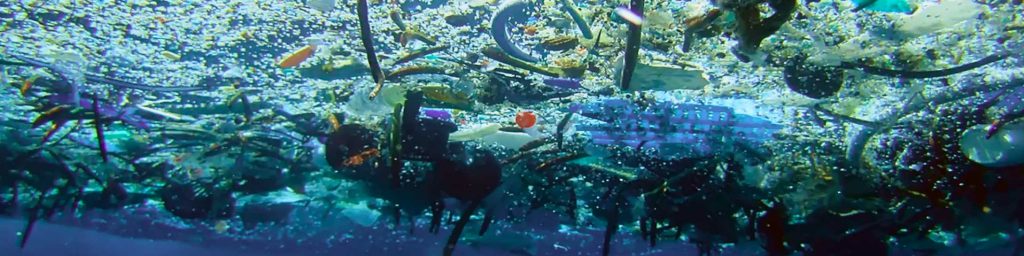 Plastikmüll schwimmt im Wasser. Aufnahme von unter Wasser.